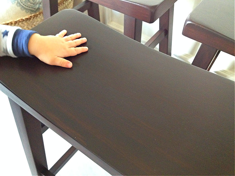 Image shows a baby hand on a stool with General Finishes Java Gel Stain before and after photos.