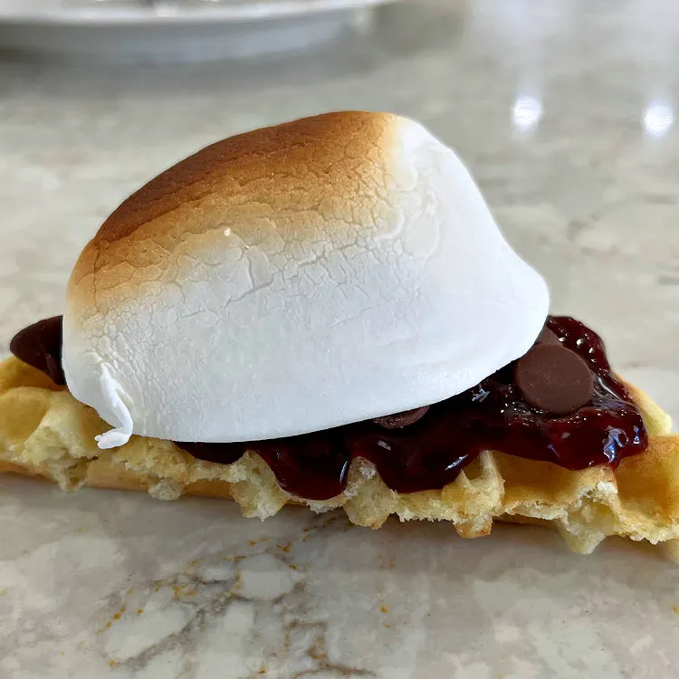Yummy Smores with Cherry Pie Filling, milk chocolate chips, and a roasted marshmallow on a waffle.