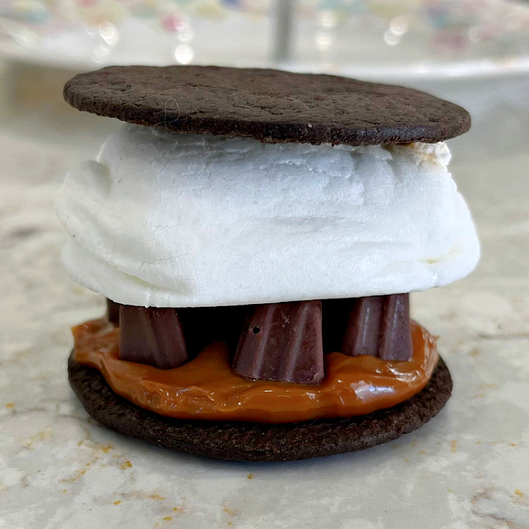 Crunchy chocolate cookies topped with a thick layer of Dulce De Leche, Chocolate Dulce De Leche truffles, and a jumbo toasted marshmallow makes a tasty Smores for chocolate and caramel combo lovers!