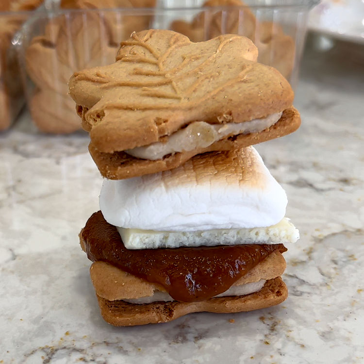 Maple cookies Smores topped with Pumpkin Spice Butter, white chocolate, and a roasted marshmallow.