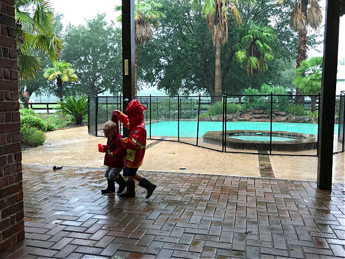 Boys outside wearing rain gear.
