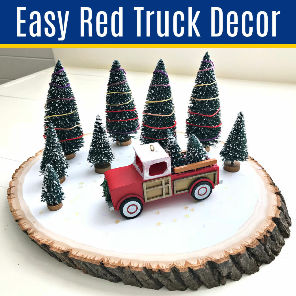 Picture of a Christmas decoration for a table top that has a Red Truck ornament and bottle brush trees.