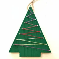 Image of a wooden Christmas Tree ornament with embroidery floss string art.