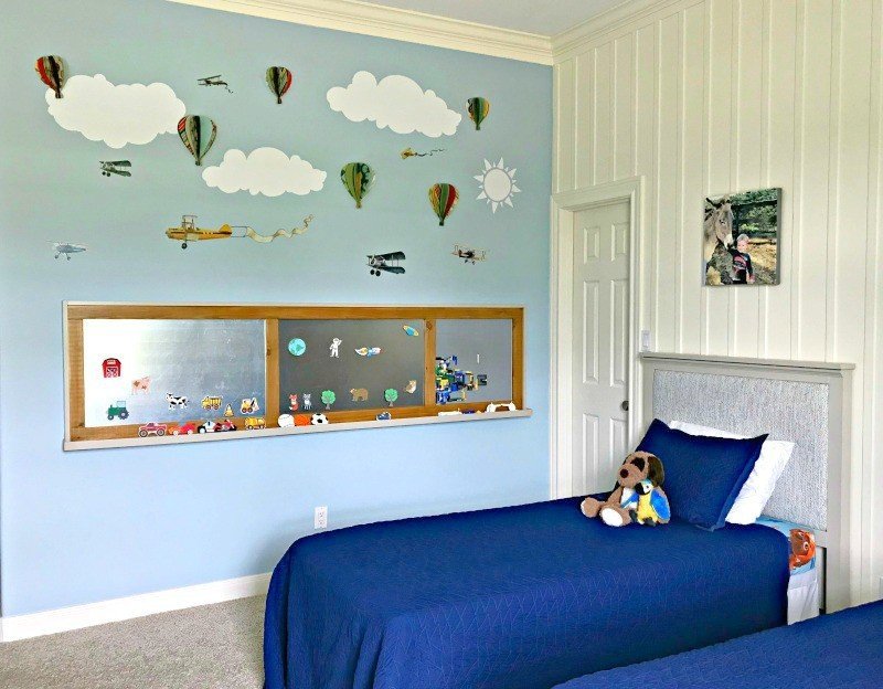It's time for the boys bedroom makeover reveal, guys! And I'm so excited to share it with you. The whole room is full of awesome DIY projects, affordable decor, and fun boys bedroom ideas. I'm loving it and so are my boy's! This is a blue, white, and grey bedroom full of pops of fun colors. I think it's a bit Farmhouse, a bit traditional, and a bit Land of Nod. I designed this for my boys, but most of the ideas would work for all kids, boys and girls. #kidsbedroom #kidsroom #boysbedroom #bedroomideas
