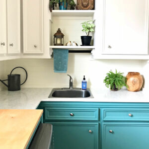 Image of Laundry Room cabinets and sink. White cabinets and counter top with teal lower cabinets.