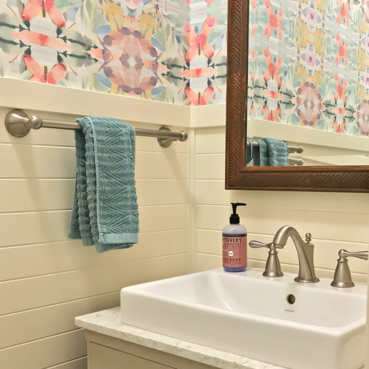 A colorful, traditional small half bath makeover with wainscoting and wallpaper.