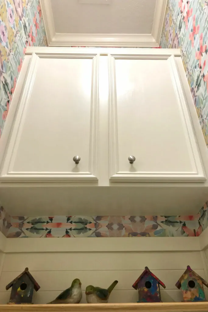 Crown molding and cabinet above the toilet in a small powder room.