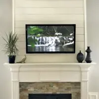 Shiplap above a white traditional fireplace mantel.