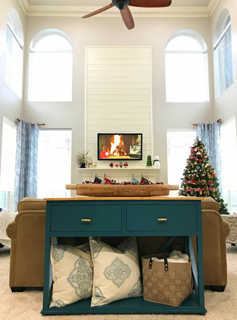 A white shiplap fireplace wall in a traditional home with a two story living room.