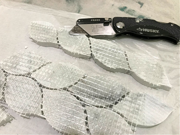 Cut the mesh backing on mosaic tile with a utility knife.
