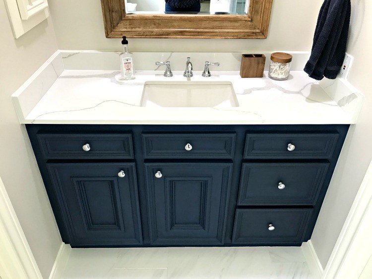 Marble Look Quartz Counters with a rectangle undermount sink and dark blue vanity. See all the details for this bathroom makeover here. #AbbottsAtHome #Quartz #Marble #Countertops #Bathroom #InteriorDesign