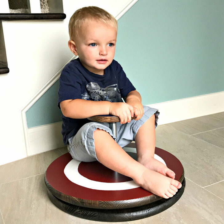 Image showing a kid on a DIY Sit And Spin Toy - for a post about how to make a Sit & Spin.