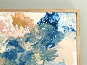 A close up of a DIY paint pour using acrylic paint. Click to see steps and how to video. #AbbottsAtHome #AcrylicPaint #AcrylicArt #Canvas #ArtIdeas #WallArt #DIYDecor #HandmadeArt