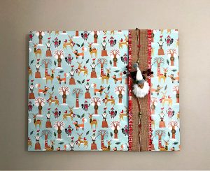 How to Wrap A Picture Frame with Wrapping Paper to make free and easy Christmas decorations. How to gift wrap your wall art with Christmas ornaments, ribbons, and gift wrap you already have. With steps and a how to video.