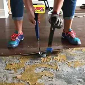 How to use a pry bar and hammer to remove glued engineered flooring on concrete.