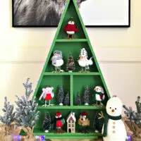 Image of a wooden Christmas Tree Display Shelf for Christmas Cards, Cookies, Ornaments, Decorations, or even a cookie and cocoa display. For a post about DIY steps and woodworking build plans.