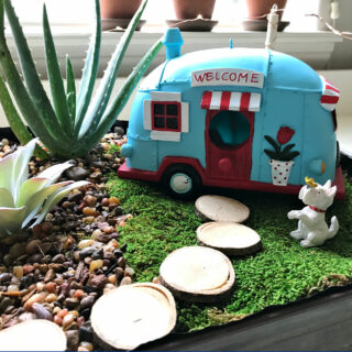 Image of Homemade DIY Indoor Fairy Garden with a Vintage Camper Van, dog, and succulent plants.
