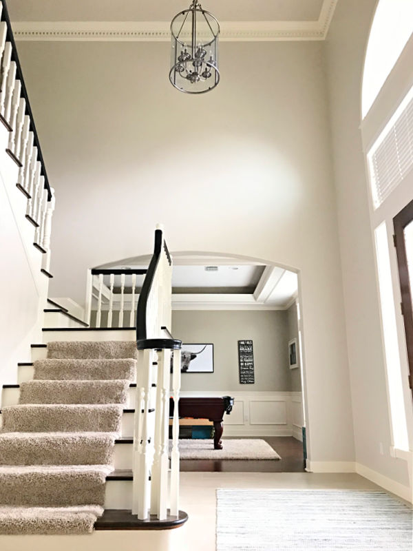 View looking up at a 2 story high foyer with light walls and stairs.