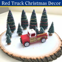 Image of easy to make Red Truck Christmas Decor using bottle brush trees, a vintage red truck, and a wood slice.