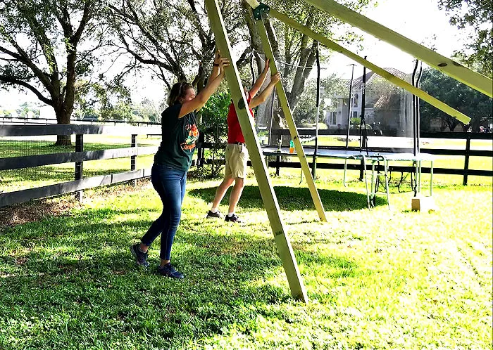 Lifting a heavy wooden swing set off the ground.
