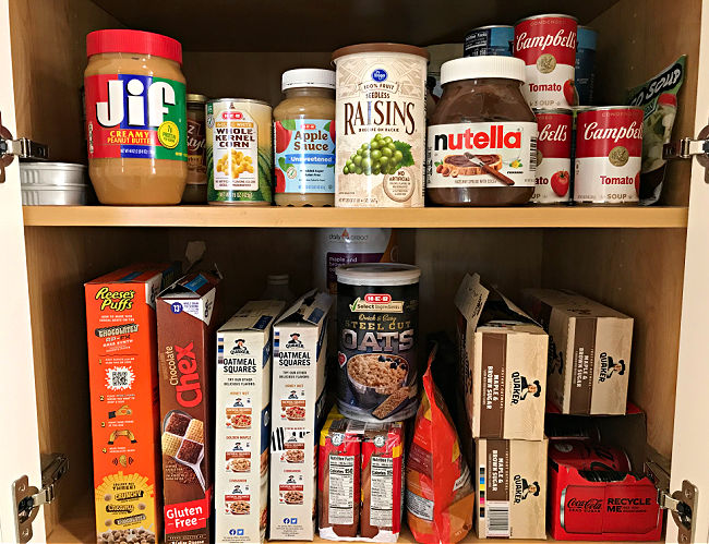 Image of kitchen cabinets full of food to stock up on for a hurricane.