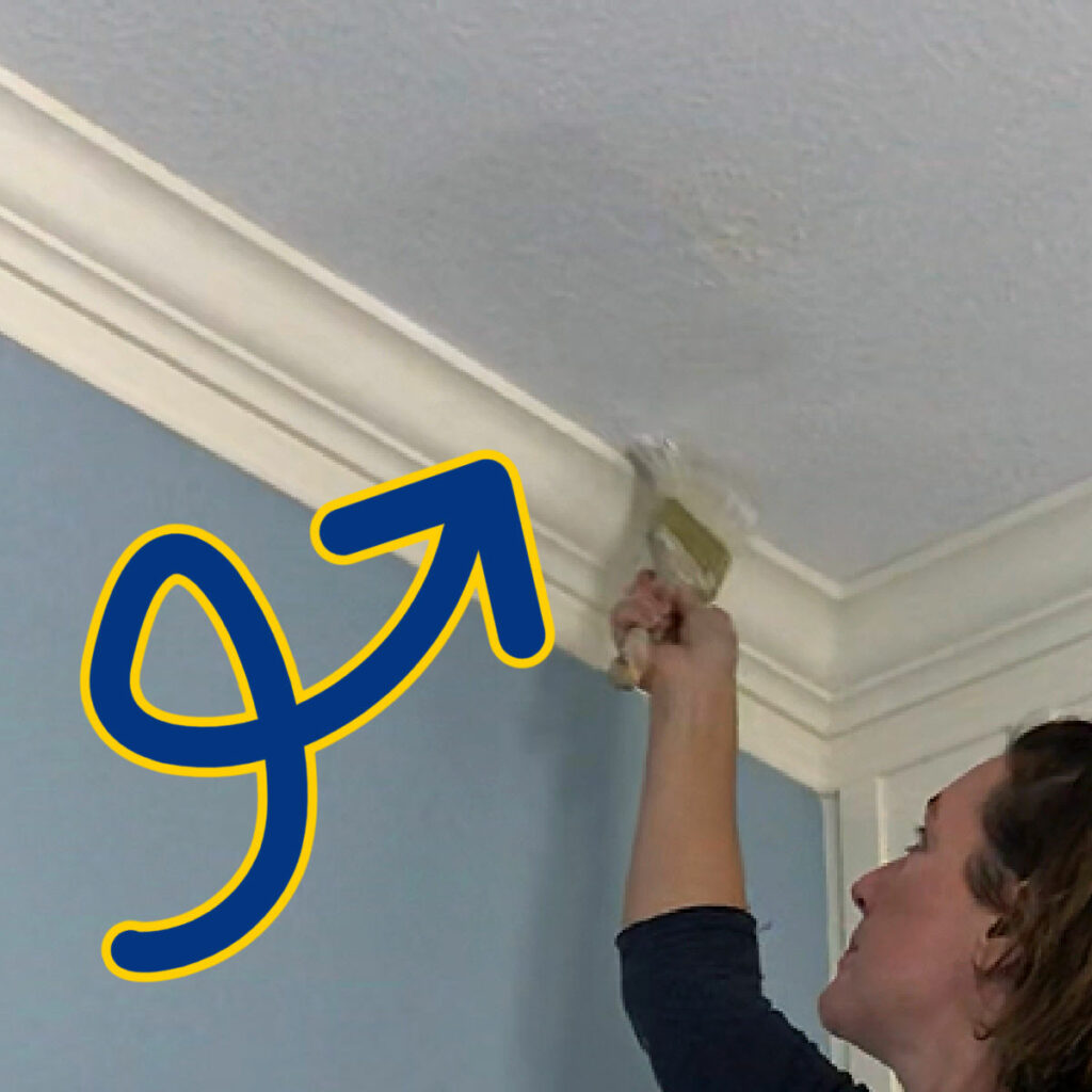 Image of a woman painting over a water stain on a ceiling.