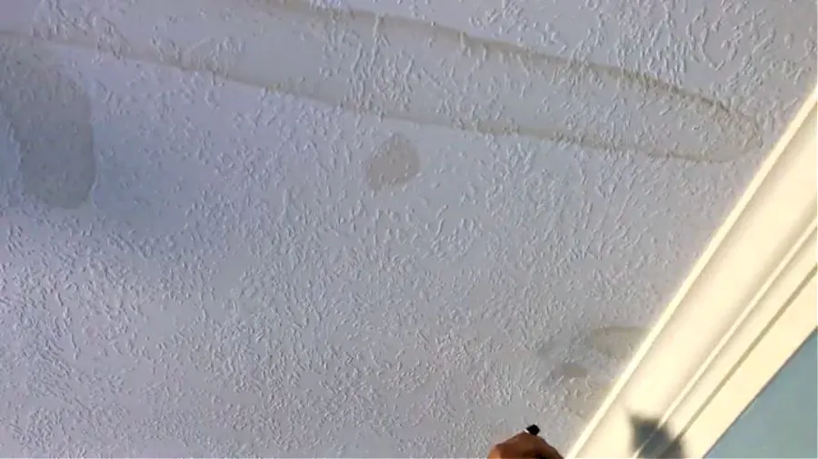 Image of multiple water stains on a white ceiling.