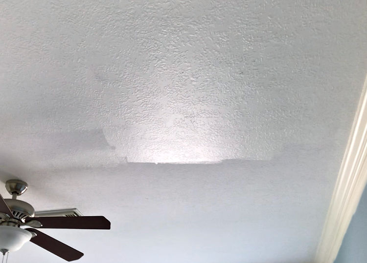 Image of a ceiling halfway painted with white eggshell sheen paint.