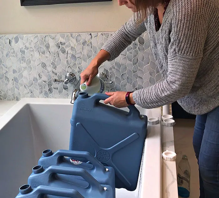 Adding bleach to clean plastic water storage containers.