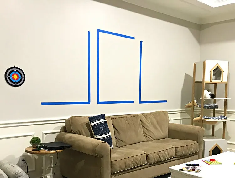Image of painters tape before hanging wall art evenly spaced on a wall.