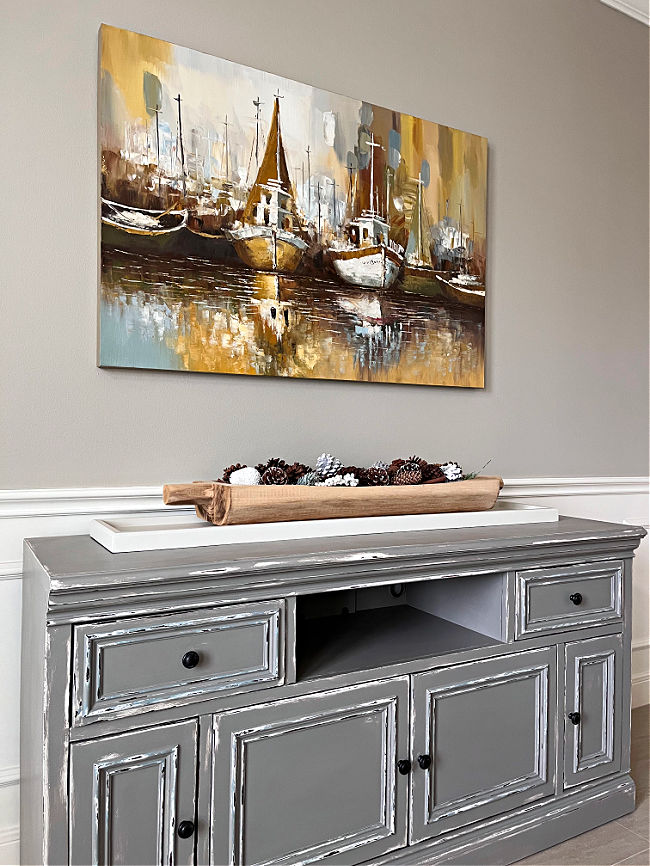 Image of decorating a large wall in a Dining Room with canvas art above a grey buffet.