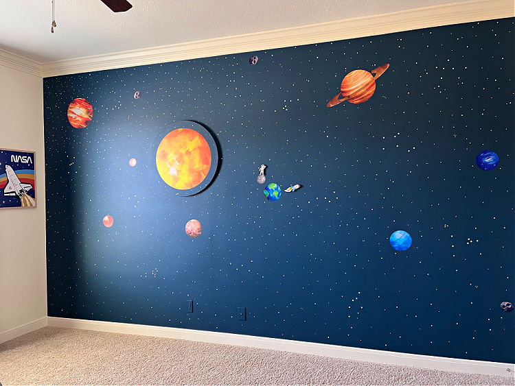 Boys bedroom with an outer space themed feature wall.