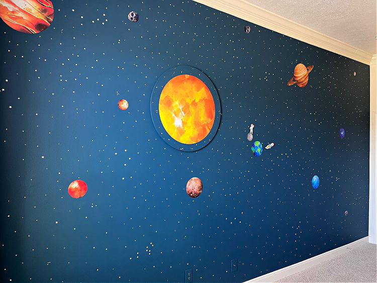 Image of an easy space-themed bedroom wall in a boys bedroom, using vinyl stickers.