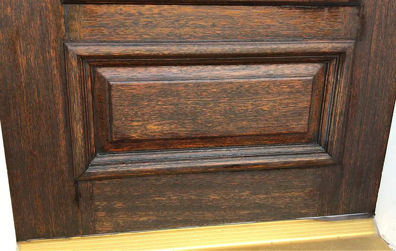 Image shows a weathered wooden front door after using a wipe on wax to repair sun damage on a dry wood door.