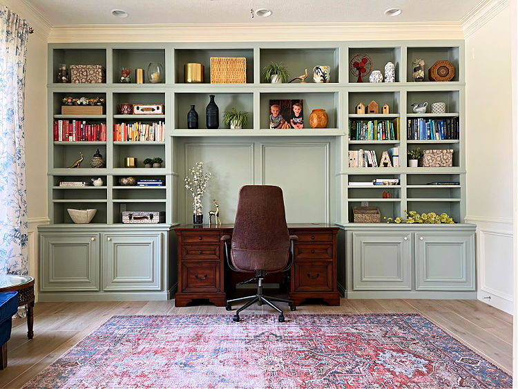 Home office with wood look tile floor, large are rug, Americana Egg green paint on the built in cabinets.