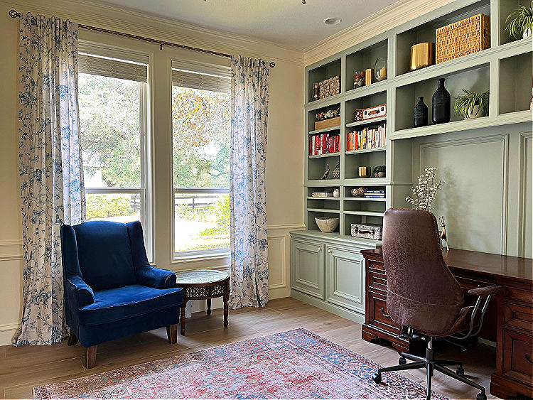 White and green home office with a lot of traditional trim and molding around the windows and on the built-in cabinets.