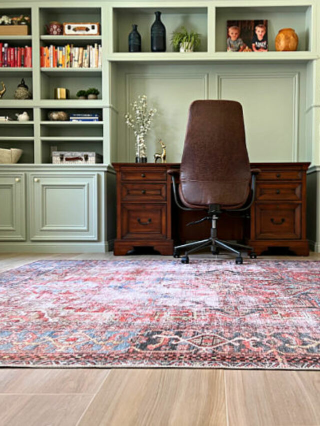 Home office with a large, traditional area rug on a faux wood tile floor, in front of built-ins.