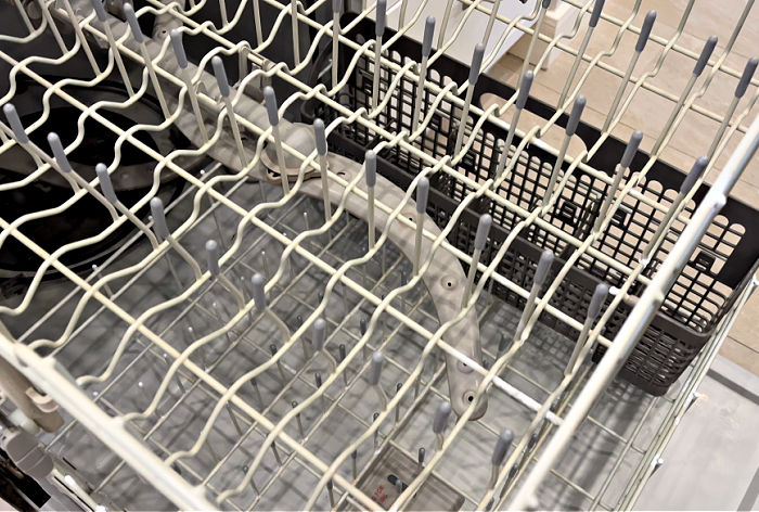 A dishwasher rack with plastic tine caps.