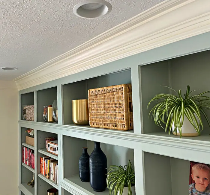 Image shows beautiful wood built ins in a home office with three piece crown molding.