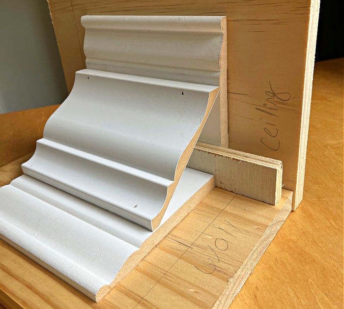 Image shows a model of stacked crown molding for a post about how to install 2 piece crown molding.