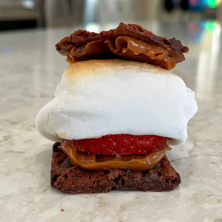 Quick Dessert Smores made with chocolate brownie brittle, Dulce De Leche, Strawberries, and marshmallow.