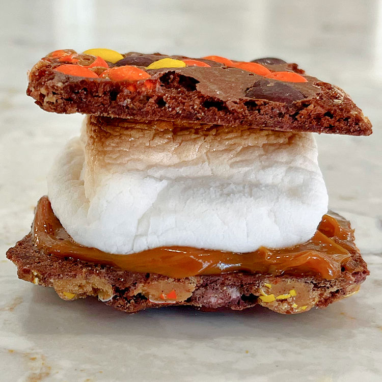 This cool Smores idea is a Reese's Pieces Brownie Brittle Smores with Dulce De Leche and Toasted Marshmallow.