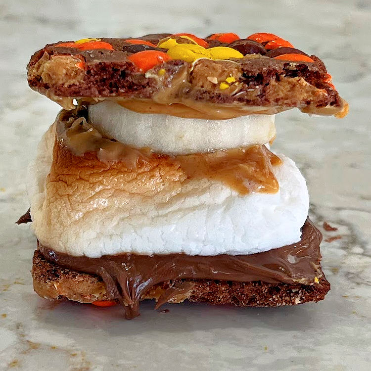 Reese's Pieces Brownie Brittle Smores Alternative with Peanut Butter, Nutella, Roasted Marshmallow, and banana.