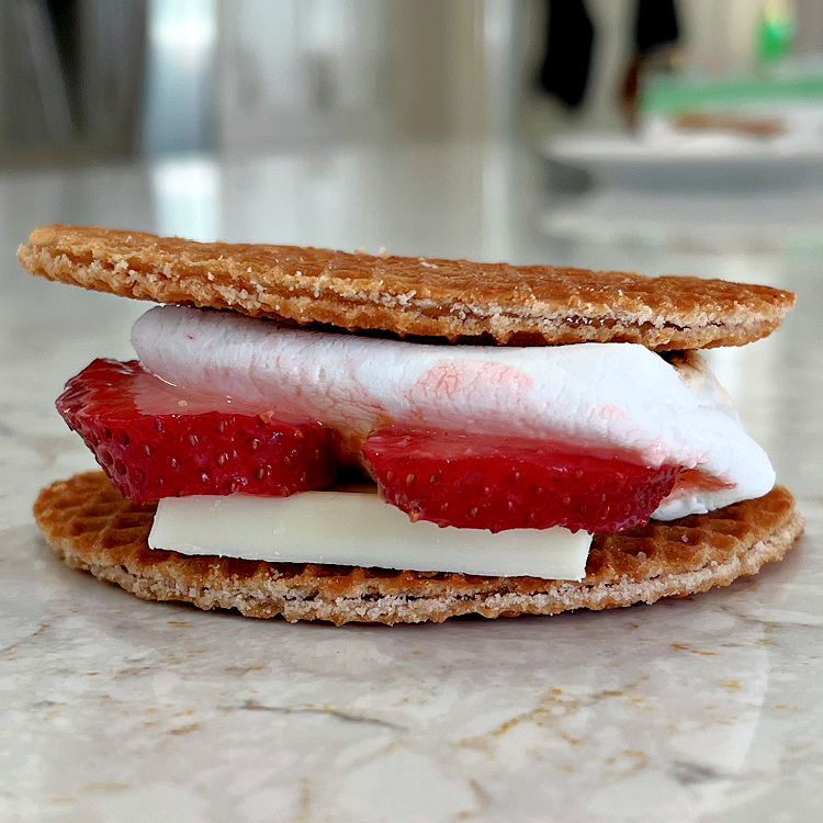 Fruit smores made with caramel filled Stroopwafel, strawberries, and white chocolate.