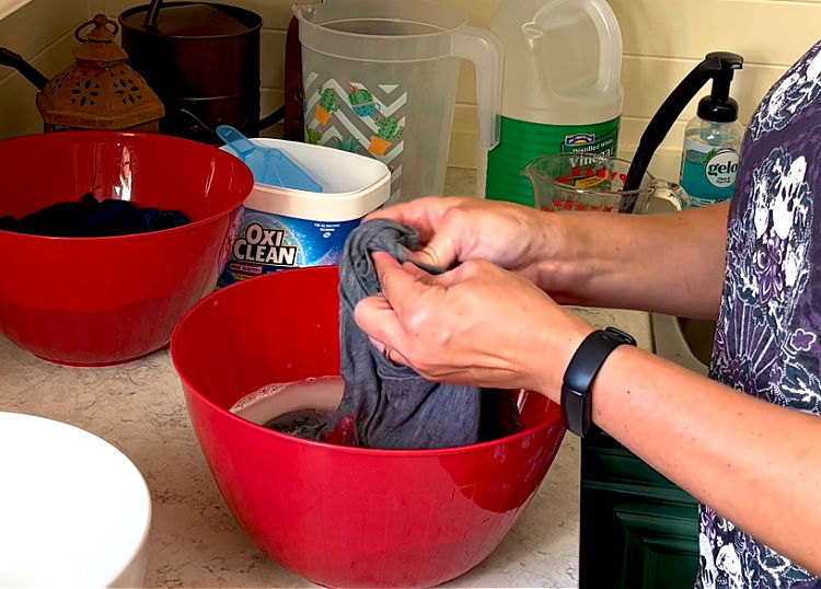 Scrubbing pit stains in a shirt before washing.