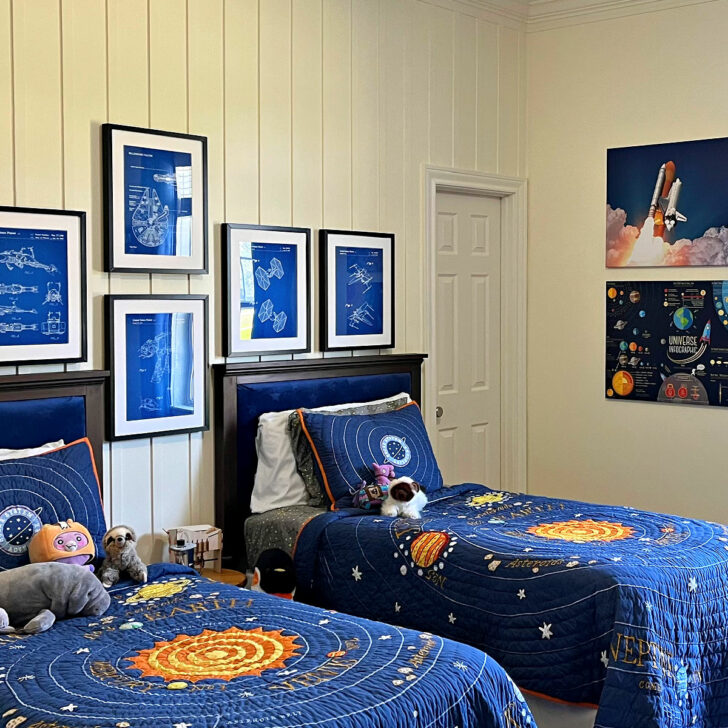 Image of a kids or teen space themed bedroom with cool space decor, Star Wars blueprints, NASA wall art, and solar system quilt from Pottery Barn.