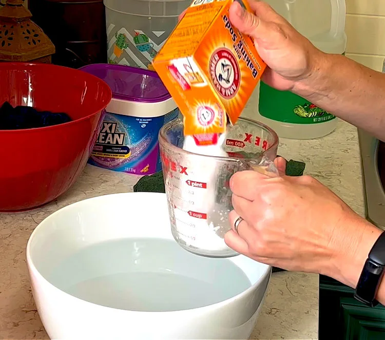 Image of someone mixing baking soda with water to remove body odor from shirts and gym clothes.