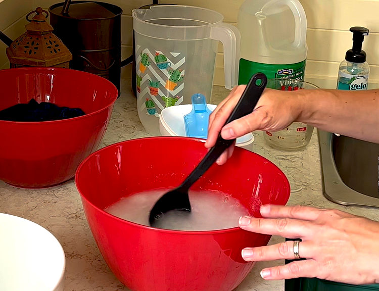 Mixing OxiClean into water to soak laundry before washing.