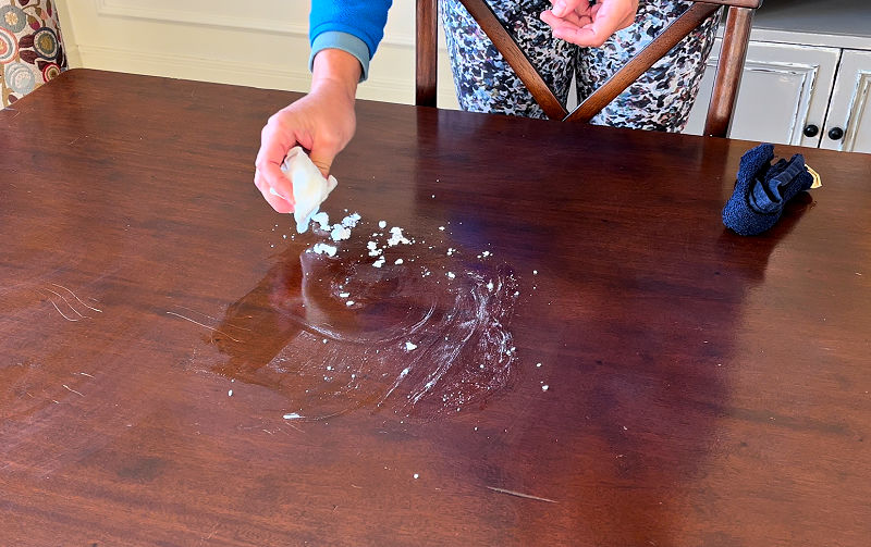 Showing how baking soda and toothpaste can remove heat marks on wood.