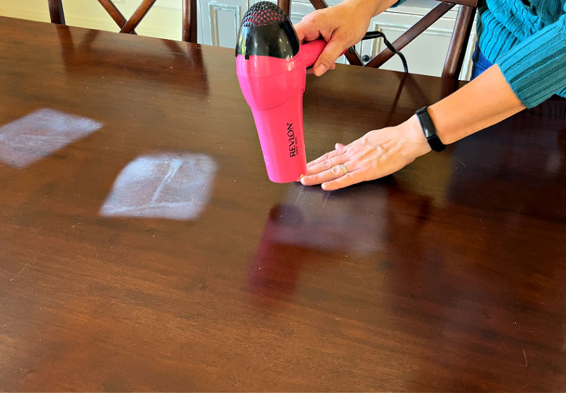 Using a blow dryer to repair heat marks on wood tables is the easiest way to remove a heat stain or water ring. 